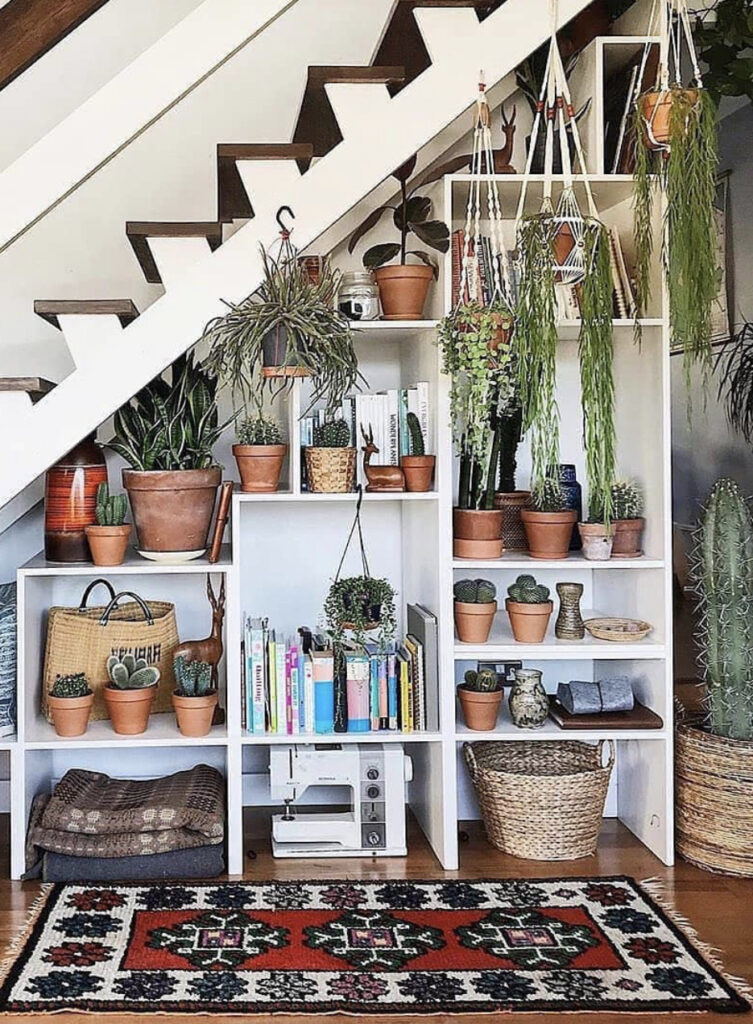 These Shelves Under the Stairs with Hanging Plants