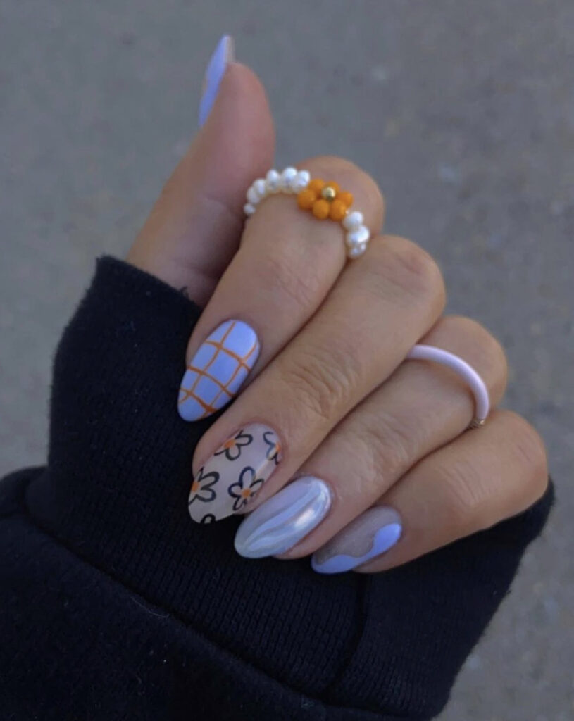White chrome, orange, and black doodle nails