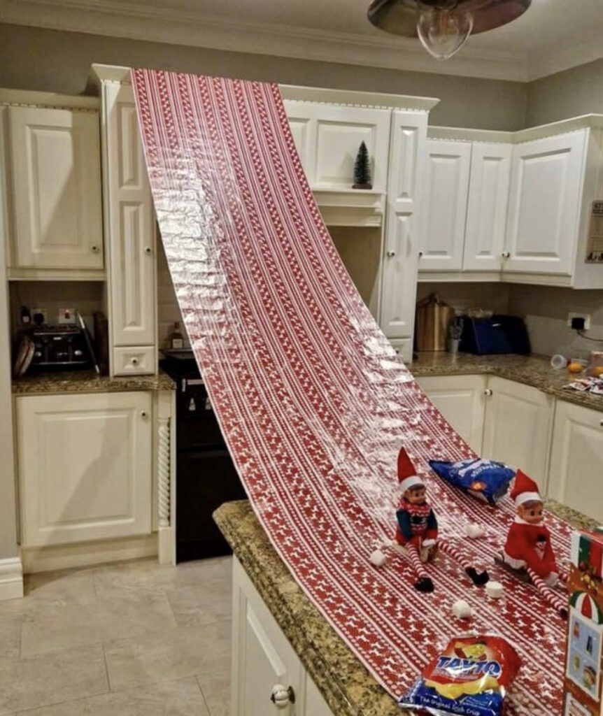 Elves made a slide out of wrapping paper in the kitchen