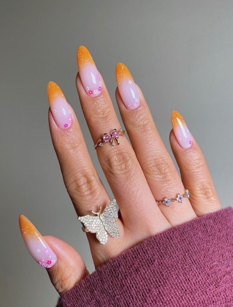 Orange sparkly ombre tips on pastel purple nails